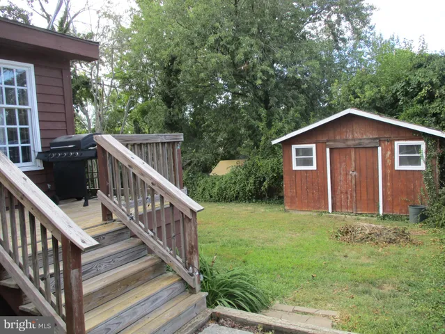 a view of a house with backyard and trees