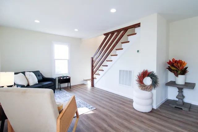 a living room with furniture and a wooden floor