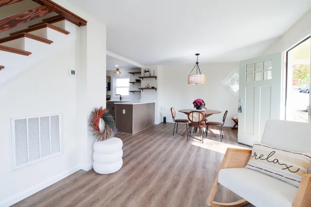 a view of a dining room with furniture a chandelier and wooden floor