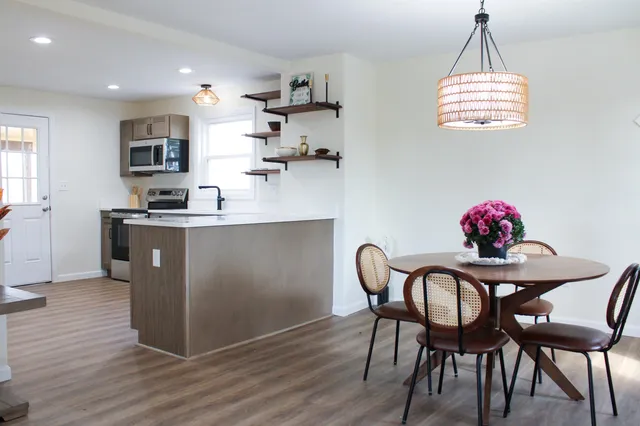 a kitchen with stainless steel appliances granite countertop a stove a sink and a microwave