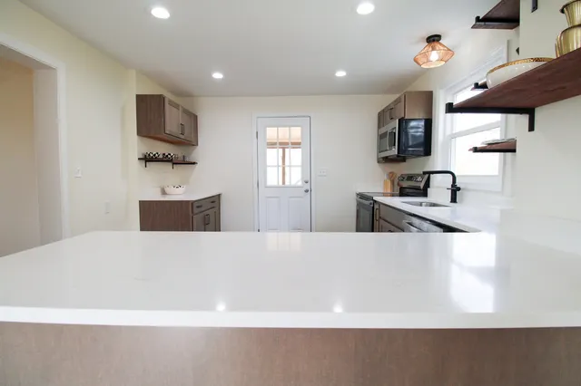 a kitchen with stainless steel appliances granite countertop a sink and a microwave