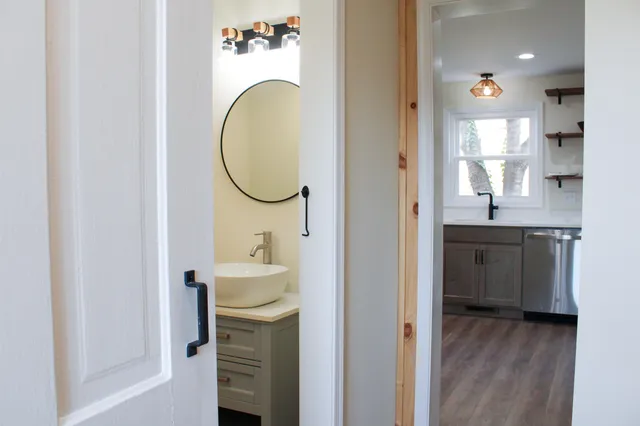 a bathroom with a granite countertop toilet sink and mirror