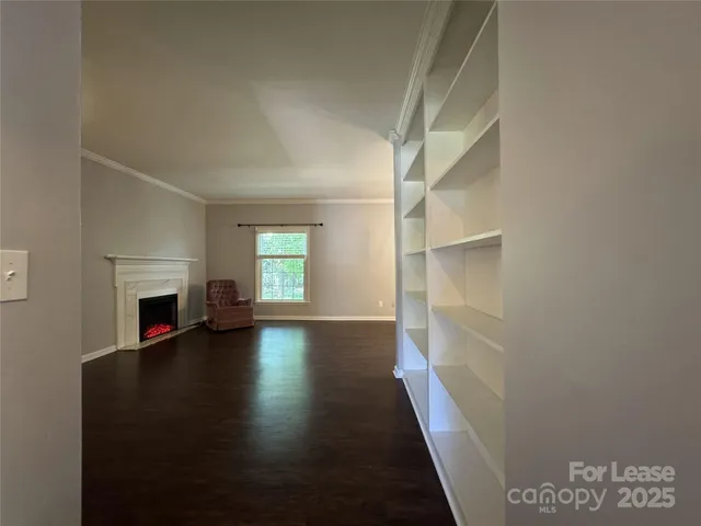 a view of empty room with fireplace and wooden floor