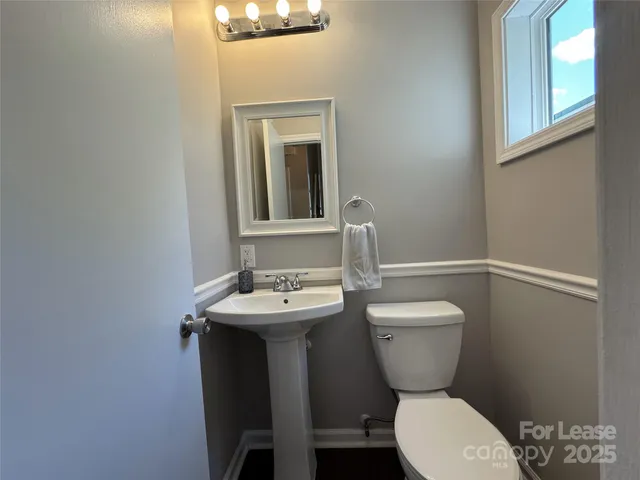 a bathroom with a toilet a sink and mirror