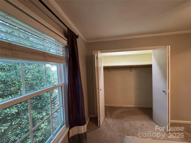 an empty room with chandelier fan and closet