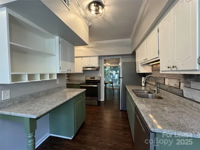 a kitchen with stainless steel appliances granite countertop a sink a stove and a refrigerator