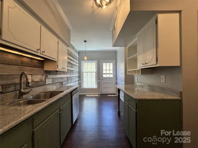 a kitchen with stainless steel appliances granite countertop a sink stove and cabinets