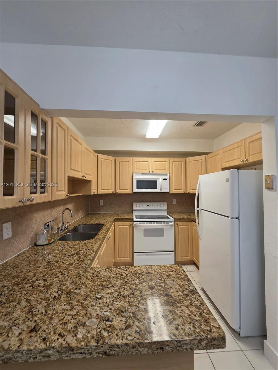 4601 Southwest 5th Street Miami, FL 33134 - Photo 12 of 23 a kitchen with stainless steel appliances granite countertop a sink stove refrigerator and cabinets