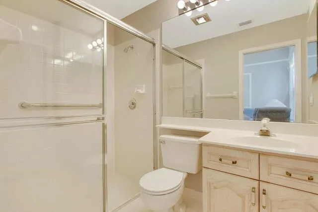 a bathroom with a sink toilet vanity and shower