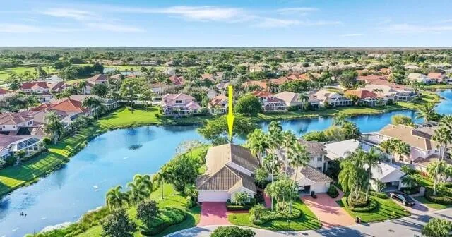 an aerial view of residential houses with outdoor space and lake view in back