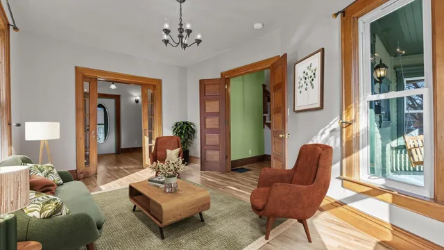 a view of an empty room with wooden floor and a window