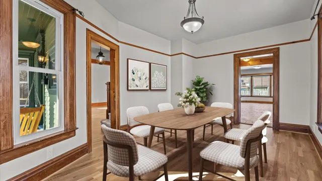an empty room with wooden floor mirror and windows