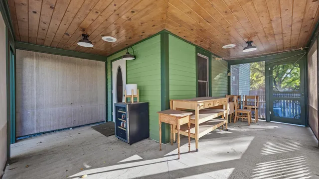 a living room with furniture a flat screen tv and floor to ceiling window