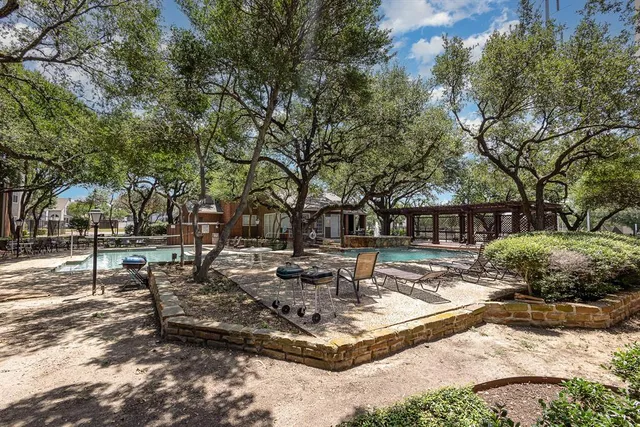 a swimming pool with outdoor seating and trees