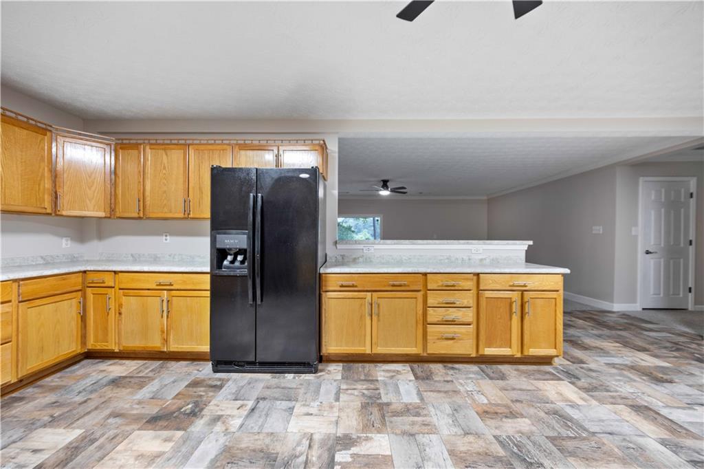25 Gas Line Road Phenix City, AL 36870 - Photo 13 of 52 Kitchen featuring black fridge, a ceiling fan, light countertops, and a peninsula