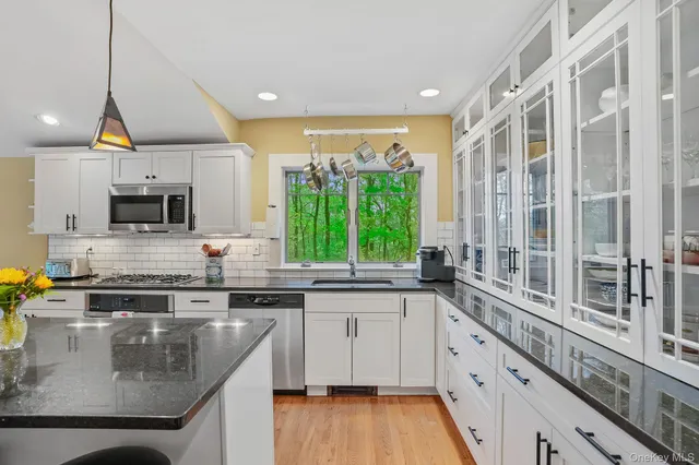 a kitchen with stainless steel appliances granite countertop a sink a stove and cabinets