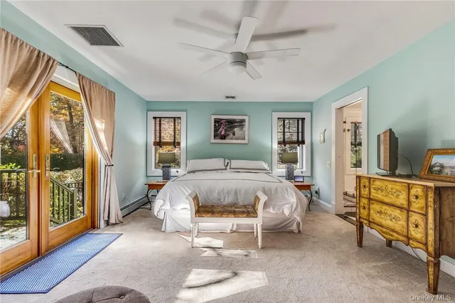 a bed sitting in a spacious bedroom next to a window