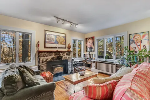 a living room with furniture a large window and a fireplace