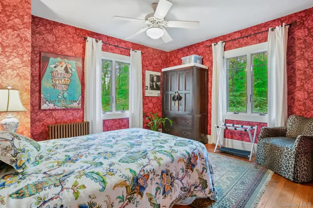 a bedroom with a bed dresser and a large window