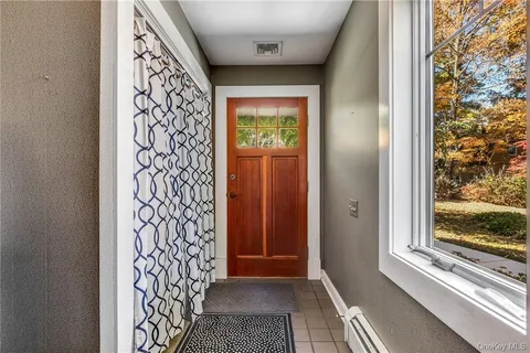 a view of a hallway with wooden floor and a livingroom with furniture
