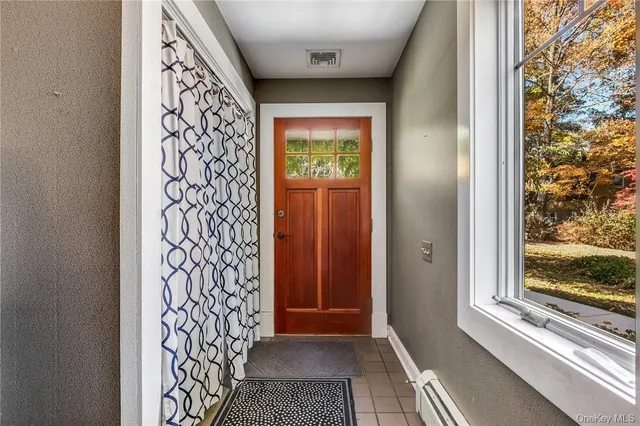 a view of a hallway with wooden floor and a livingroom with furniture
