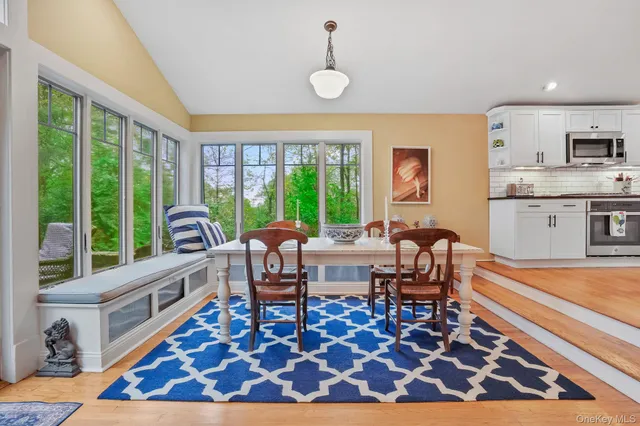 a living room with furniture a rug and a floor to ceiling window