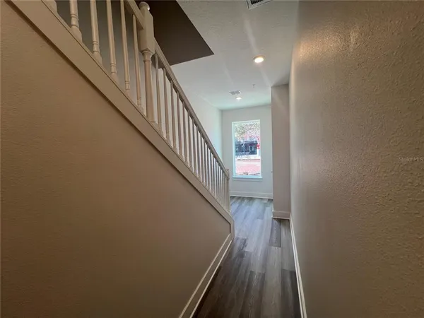 a view of entryway and hall with wooden floor