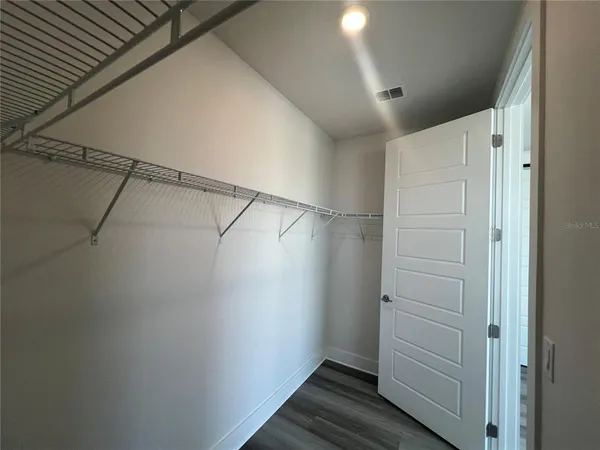 an empty room with wooden floor and closet