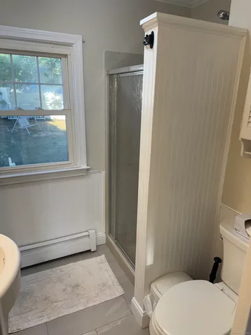 a bathroom with a toilet and a shower