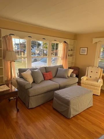 a living room with couches and a large window with wooden floor