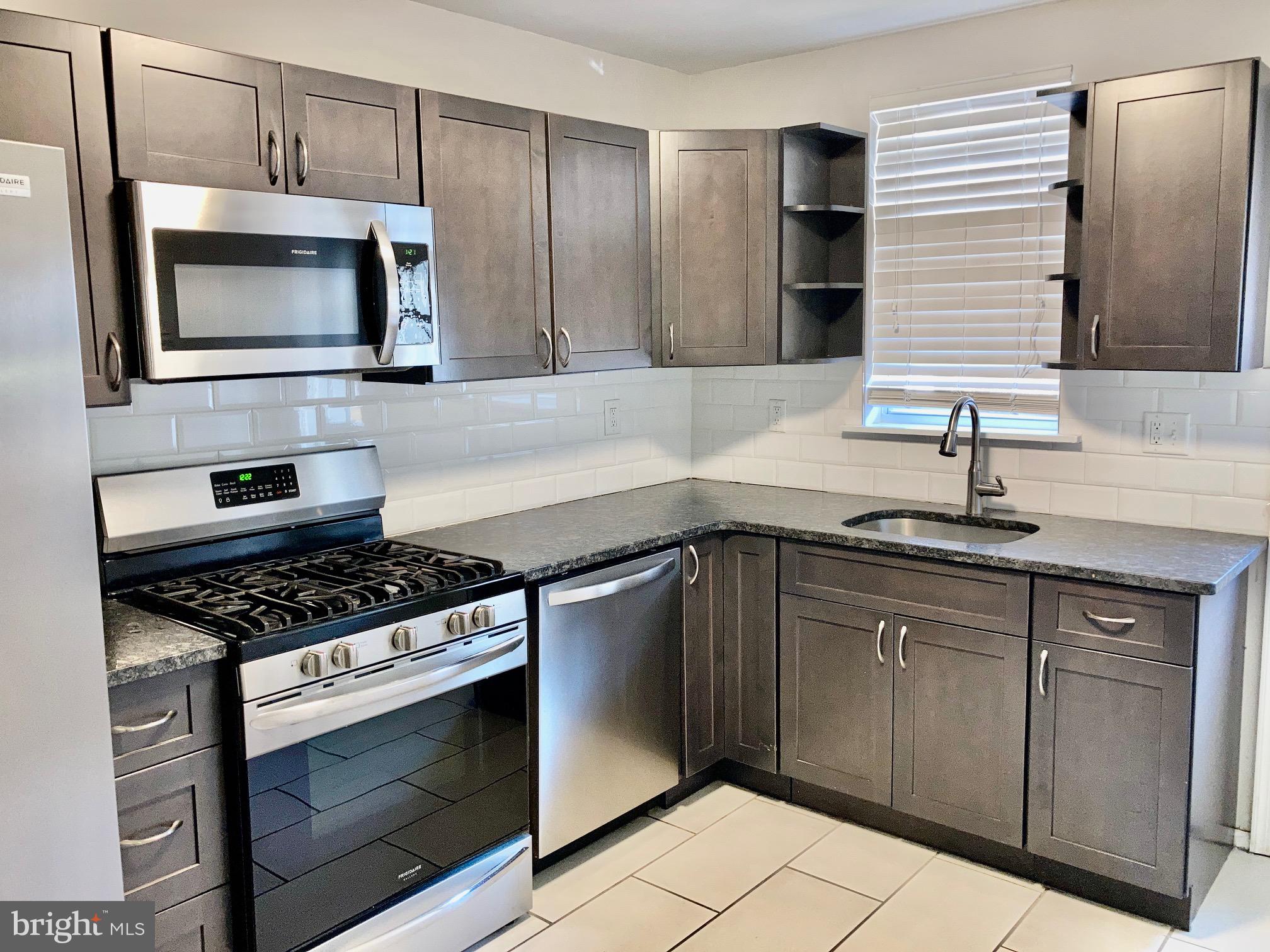 2647 South 12th Street Philadelphia, PA 19148 - Photo 7 of 19 a kitchen with stainless steel appliances a stove a microwave and sink