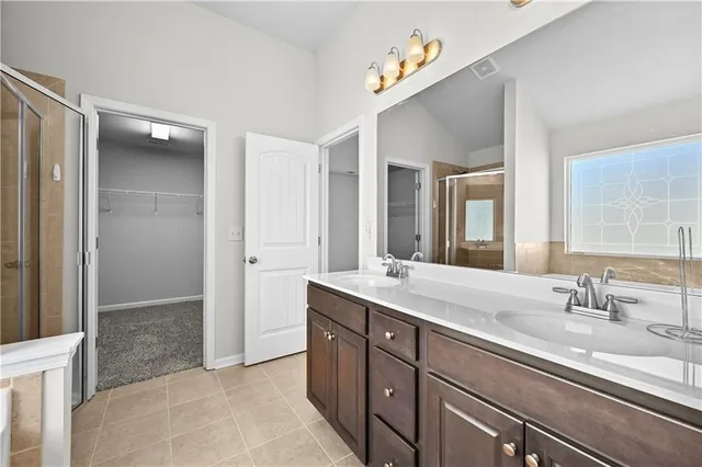 a bathroom with a tub shower sink and mirror