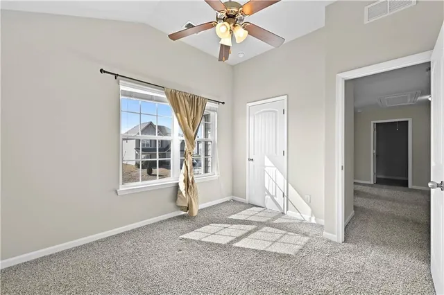 an empty room with a window and a fan