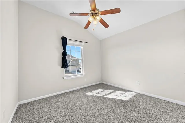 an empty room and a chandelier fan