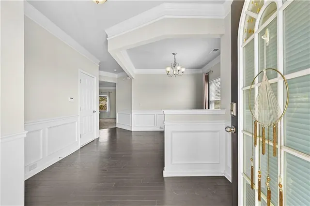 a view of a hallway with wooden floor and a bathroom