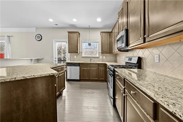 a kitchen with granite countertop stainless steel appliances and wooden cabinets