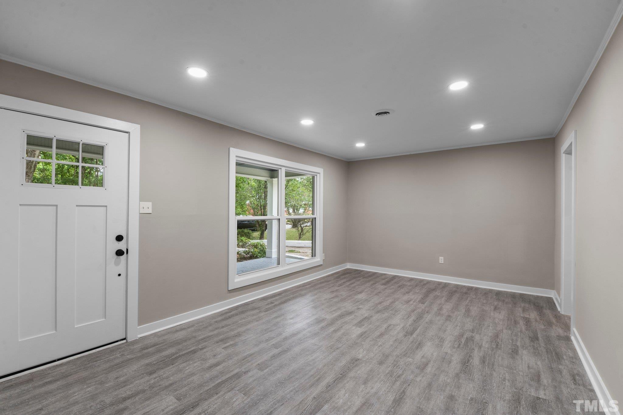 801 Friar Tuck Road Raleigh, NC 27610 - Photo 21 of 24 a view of an empty room with wooden floor and a window