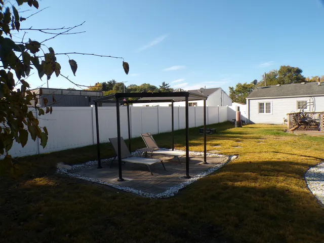 a backyard of a house with table and chairs