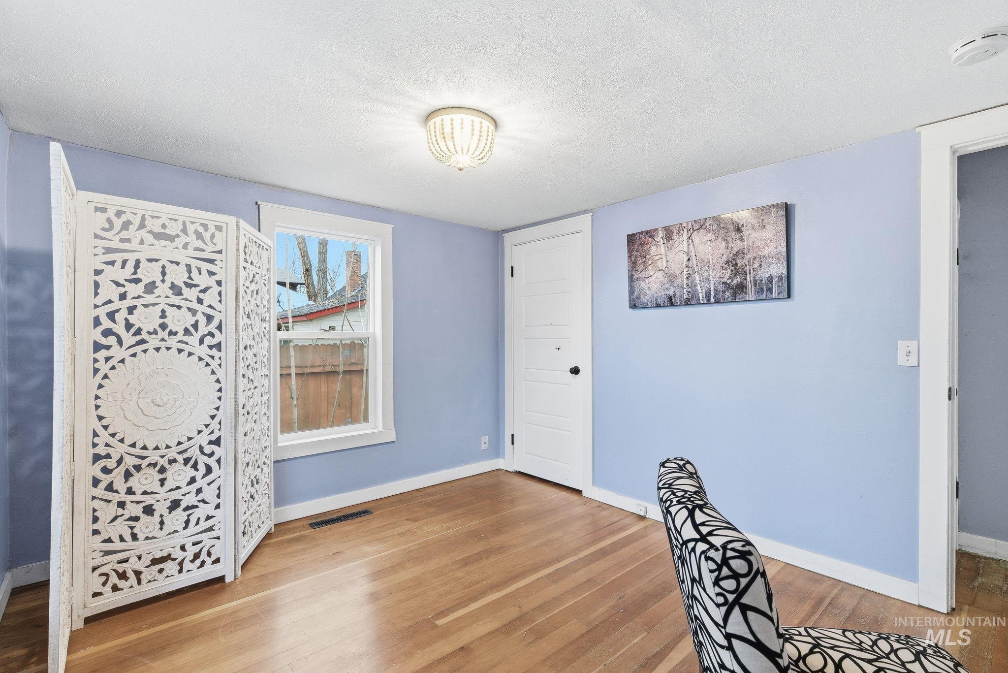 2103 West Bannock Street Boise, ID 83702 - Photo 18 of 49 Unfurnished bedroom with light wood-style flooring and a textured ceiling