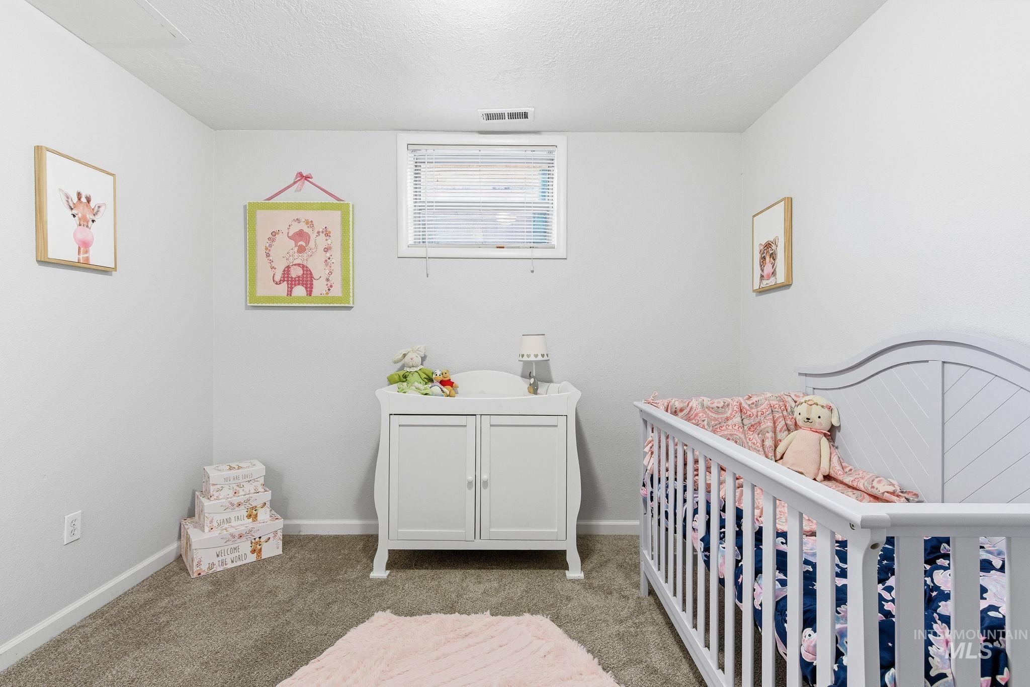2103 West Bannock Street Boise, ID 83702 - Photo 26 of 49 Carpeted bedroom with a textured ceiling and a nursery area