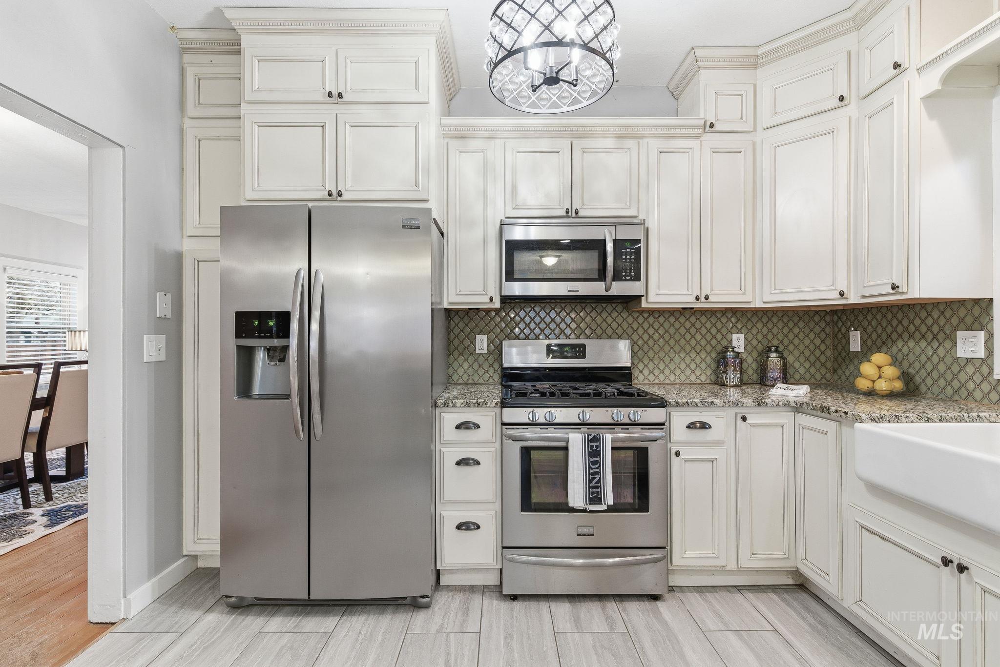 2103 West Bannock Street Boise, ID 83702 - Photo 10 of 49 Kitchen with stainless steel appliances, light stone counters, and tasteful backsplash