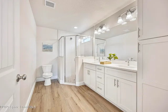 a spacious bathroom with a double vanity sink toilet and a shower