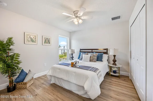 a bedroom with a bed and a potted plant