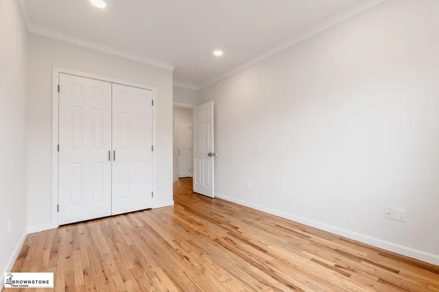 a view of an empty room with wooden floor