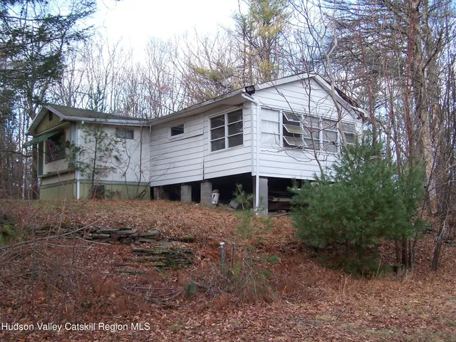 a view of a house with a yard and large tree