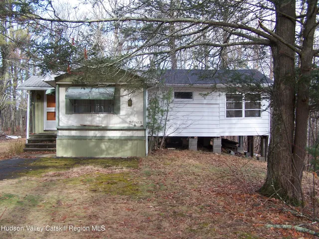 a view of a house with a large tree and a yard
