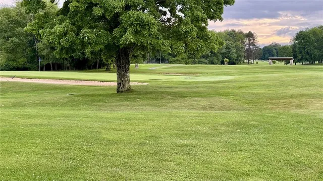 a living room with furniture floor to ceiling window and wooden floor