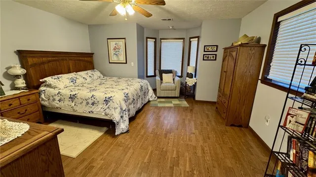 a bedroom with a bed a flat screen tv and dresser