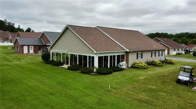 a aerial view of a house next to a yard with big trees