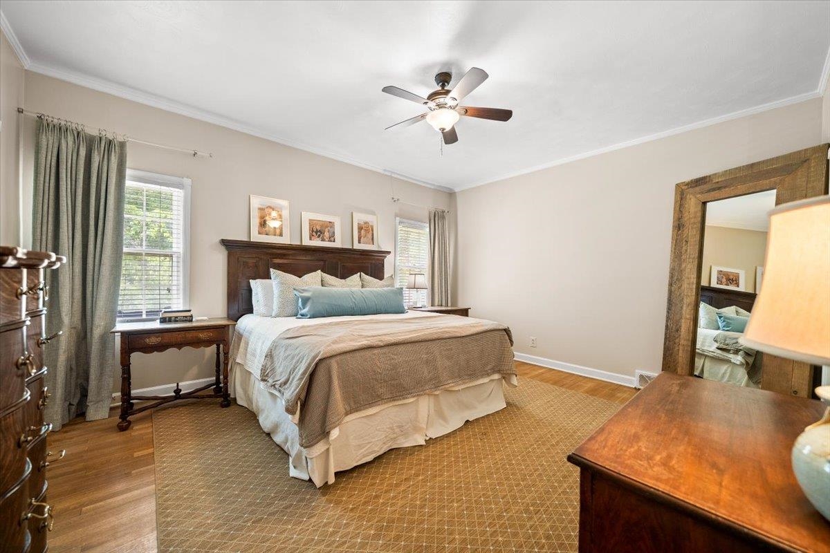 1273 Brookfield Road Memphis, TN 38119 - Photo 21 of 40 Large primary bedroom featuring wood-finish flooring, a ceiling fan with integrated lighting, crown molding, and multiple windows with blinds